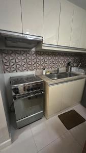 a kitchen with a sink and a stove at KL Rooms at Greenbelt makati with cityview in Manila