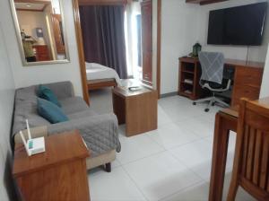 a living room with a couch and a desk and a television at KL Rooms at Greenbelt makati with cityview in Manila