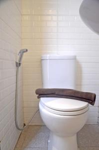 Alodia Powered by Archipelago في Tanjungkarang: حمام مع مرحاض أبيض مع دش