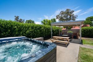 a hot tub in a backyard with a picnic table at The Hallows Accommodation in Bathurst +39 photos