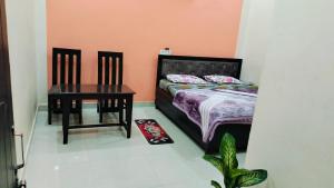 a small bedroom with a bed and a table at Kamla Sadan Palace in Ayodhya