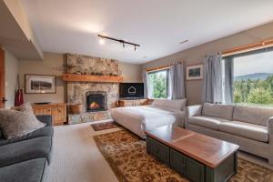 a living room with a couch and a fireplace at Heron Chalet by Outpost Whistler in Whistler