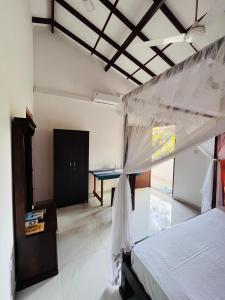 a bedroom with a bed and a table in it at Anthony Guesthouse in Hikkaduwa +21 photos