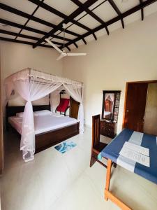 a bedroom with a bed with a mosquito net at Anthony Guesthouse in Hikkaduwa
