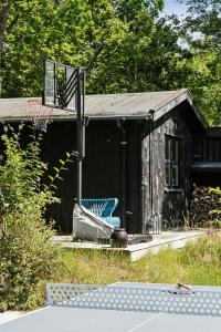 una silla azul sentada fuera de un edificio en Architect Designed With Two Wings By Tisvilde Hegn, en Tisvildeleje
