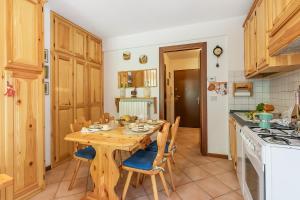 een keuken met een houten tafel en stoelen bij Relax In Pineta - Happy Rentals in Oulx