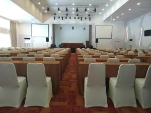 una gran sala con filas de mesas y sillas en Wing Hotel Kualanamu Airport, en Kampungbesar 201 fotos más