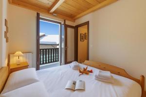 een slaapkamer met een wit bed en een groot raam bij Maison Dolce Vento - Happy Rentals in Oulx