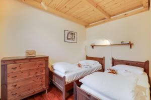 een slaapkamer met 2 aparte bedden en een dressoir bij Maison Dolce Vento - Happy Rentals in Oulx