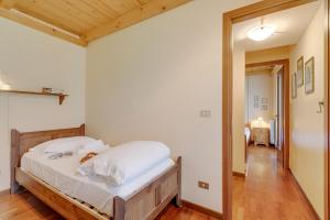 een slaapkamer met een bed met witte lakens en een spiegel bij Maison Dolce Vento - Happy Rentals in Oulx