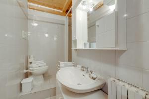 een witte badkamer met een wastafel en een toilet bij Maison Dolce Vento - Happy Rentals in Oulx