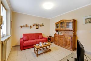 een woonkamer met een rode bank en een houten kast bij Maison Dolce Vento - Happy Rentals in Oulx +15 foto's