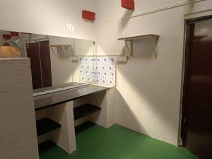 een kleine keuken met groene vloeren en een aanrecht bij PARV Farms in Belgaum