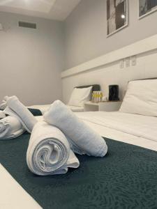 Habitación con 2 camas y toallas blancas. en NOVADECI Suites, en Manila