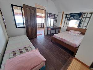 een kamer met twee bedden en een tafel erin bij Paseo Del Mar Seaside Inn in Jagna