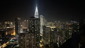 a view of a large city at night at Vortex KLCC by apartx in Kuala Lumpur