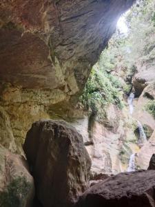 a view of a rocky canyon with a waterfall at La carpa de Nilo in Nilo