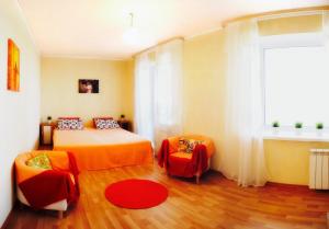 ハバロフスクにあるApartments on Sheronova 10 Orangeのベッドルーム1室(ベッド1台、ソファ、窓付)
