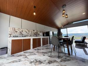 una cucina con un tavolo e sedie in una stanza di Tera Bali Villa Bedugul 2 a Bedugul