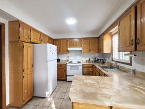 una cucina con mobili in legno e un frigorifero bianco di Relocation Ready- Pet-Friendly 4BR-Core of transit a Vaughan
