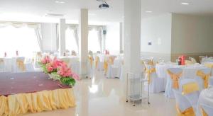 a banquet hall with white tables and yellow chairs at Royal Hill Satun Hotel in Ban Pak Ba Ra +86 photos