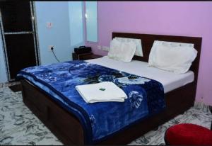 a bedroom with a bed with a blue comforter at Kamla Sadan Palace in Ayodhya