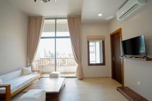 un salon avec un canapé et une grande fenêtre dans l'établissement Emerald Resort Hikkaduwa, à Hikkaduwa