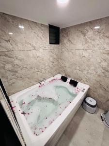 Un baño con una bañera cubierta de salpicaduras en Hotel Grand Lake, en Ahmedabad