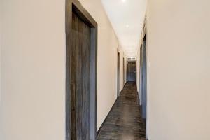 pasillo con paredes blancas y puerta de madera en Townhouse LBS Road BKC Formerly Royal Palace, en Bombay