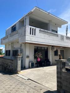 uma grande casa branca com uma entrada para carros em Sunkissed Divers Okinawa Yomitan Guest House 1 em Yomitan