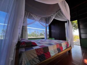 a bedroom with a bed with a canopy and a window at The Rustic Tree Farm in Thôn An Thạnh +16 photos