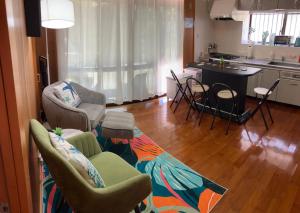 uma sala de estar com cadeiras e uma cozinha em Sunkissed Divers Okinawa Yomitan Guest House 1 em Yomitan