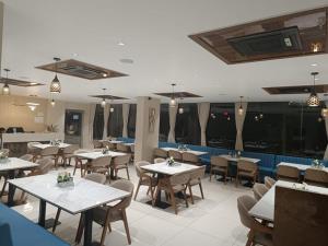 een eetkamer met tafels en stoelen in een restaurant bij hotel monville in Vadodara