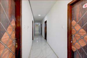 an empty corridor with doors and a hallway at Hotel O Film City Hyderabad Formerly RJ Residency in Pedda Ambarpet