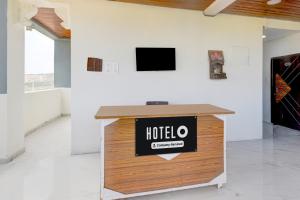 a reception desk with a hotel sign on it in a room at Hotel O Film City Hyderabad Formerly RJ Residency in Pedda Ambarpet