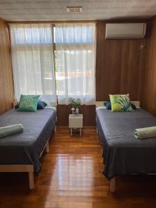 um quarto com duas camas e uma janela em Sunkissed Divers Okinawa Yomitan Guest House 1 em Yomitan