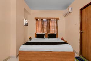 Un dormitorio con una cama grande frente a una ventana. en Super Collection O Biswa Bangla Convention Centre Kolkata Formerly Atithya Inn, en New Town 22 fotos más