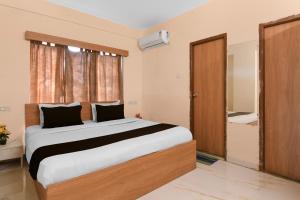 Un dormitorio con una cama grande y un baño. en Super Collection O Biswa Bangla Convention Centre Kolkata Formerly Atithya Inn, en New Town