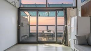 Una cocina con una puerta corrediza de vidrio que conduce a una mesa de comedor. en Sacheon Bichae Pension, en Sacheon