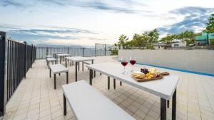 una fila de mesas con copas de vino en un balcón en Sacheon Bichae Pension, en Sacheon
