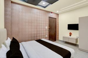 Un dormitorio con una cama grande y un televisor de pantalla plana. en Townhouse Subharti University Meerut Formerly Hotel Celebration, en Panchli 21 fotos más