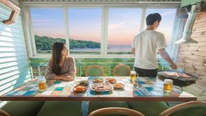 een man en een vrouw aan een tafel met eten bij Ganghwa Ara Pension in Incheon