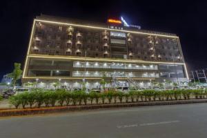 een groot gebouw met auto's ervoor geparkeerd bij hotel monville in Vadodara