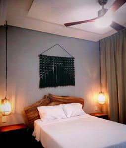 een slaapkamer met een wit bed met 2 lichten aan bij The Empire Amira in Tulum +74 foto's