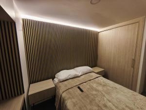 a small room with a bed and a door at Barranquero Coffee Loft in Santa Rosa de Cabal