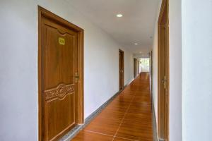 pasillo vacío con puerta de madera y suelo de madera en Super Collection O Siolim Formerly Celeb Da Luna, en Agarvado