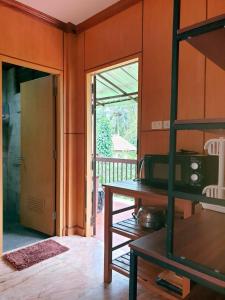 a kitchen with a table and a door to a porch at Thai House by Dow Residence in Lamai