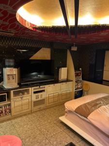 ein Schlafzimmer mit Bett und Flachbildfernseher in der Unterkunft ホテルエルリゾート in Koriyama