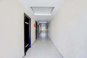 an empty corridor in an office building with a white hallway at Super Hotel O Rajahmundry Central Railway Station Formerly Sanjeevi Residency in Godāvari