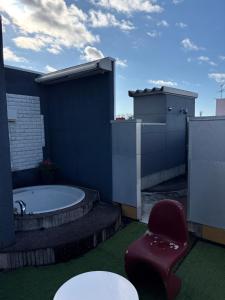 ein Badezimmer mit einer Badewanne, einem Stuhl und einem Tisch in der Unterkunft ホテルエルリゾート in Koriyama